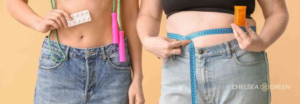 Woman holding Orlistat fat burning pills in front of their stomachs. 
