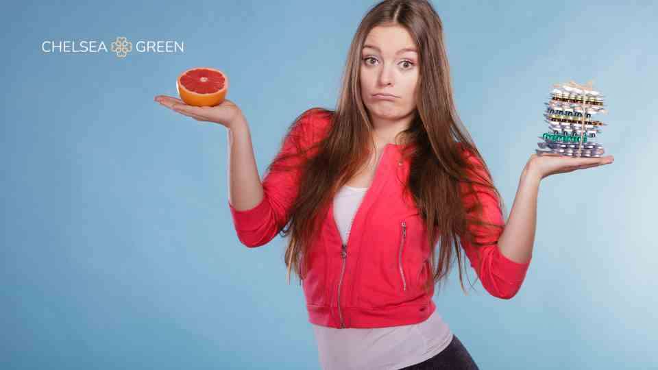 Weight loss tablets and a grapefruit to represent healthy eating