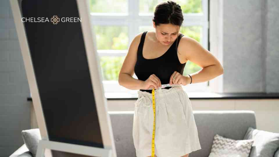 Woman measuring weight loss progress