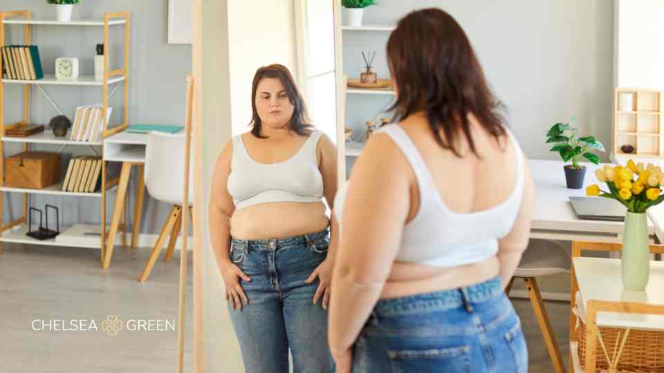 Woman looking at weight in the mirror