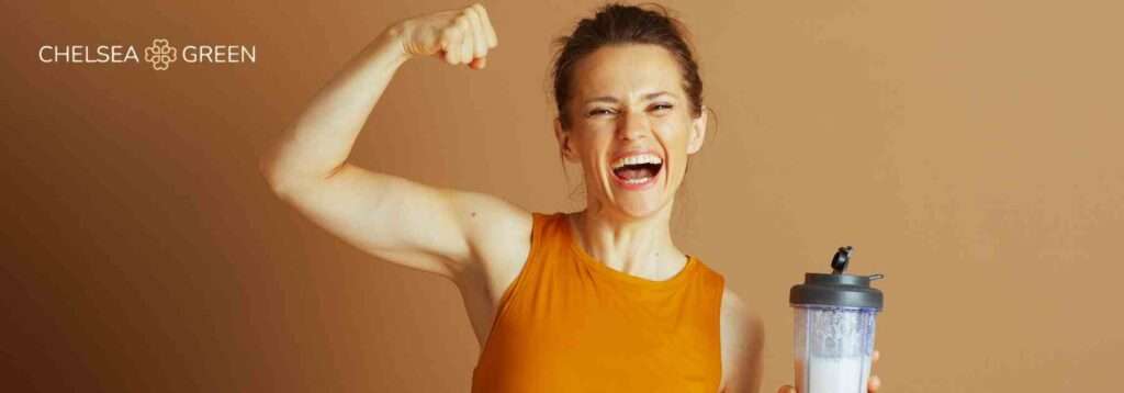 Woman flexing drinking a protein shake