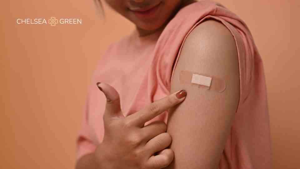 Woman pointing to vaccine location on upper arm