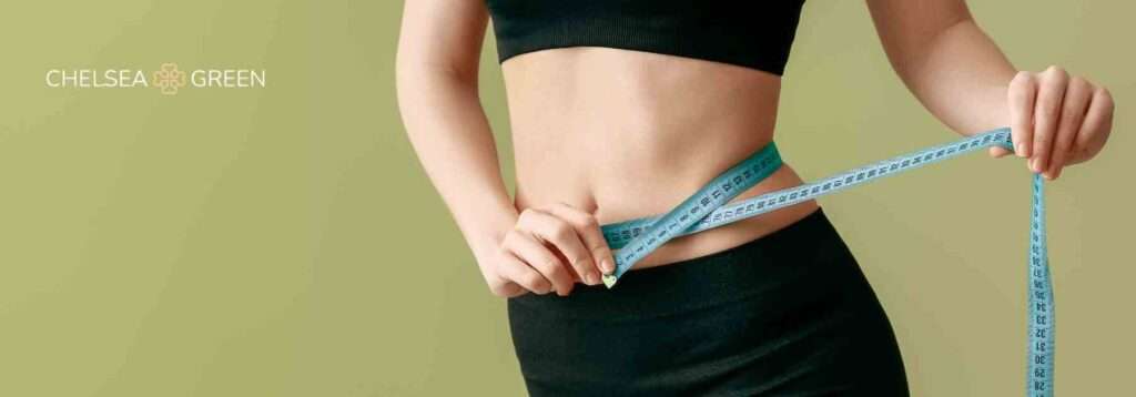 Woman holding a measuring tape to her waist