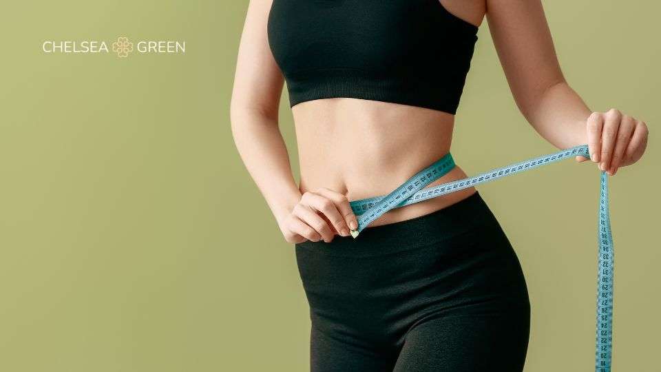 Woman measuring weight loss with a measuring tape
